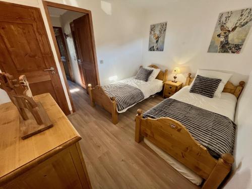 een slaapkamer met twee bedden en een spiegel bij Résidence Grand Bois A1124 Clés Blanches in La Tania