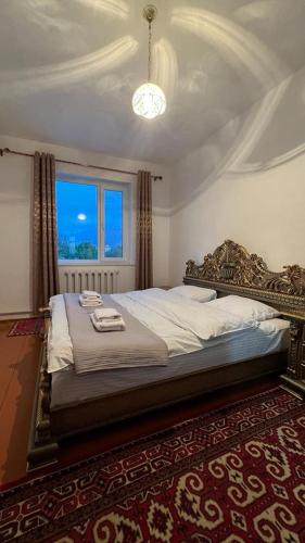 a bedroom with a large bed with a large window at Гостевой дом “Kyzyl Alma” (Red Apple) in Chon-Dzhargylchak