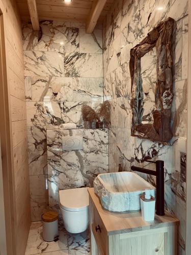 a stone bathroom with a sink and a toilet at Osada Snozka in Kluszkowce