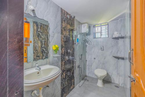 uma casa de banho com um lavatório e um WC em The Sequeira Goa em Majorda