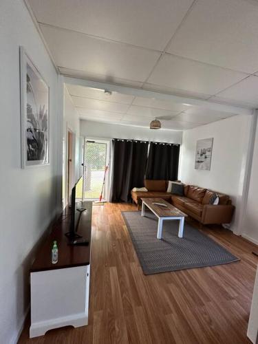 a living room with a couch and a table at Cottage 3mn walk CBD/Marina. Wifi,AC, pet-friendly in Nelson Bay