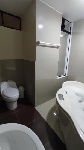 uma casa de banho com um WC branco e um lavatório. em HOTEL LA BELLA Y EL LEON em Huánuco