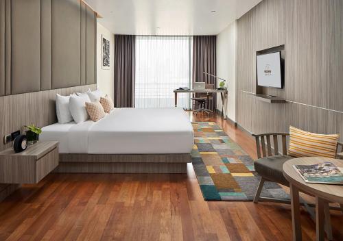 1 dormitorio con cama, mesa y sofá en Fraser Suites Sukhumvit Bangkok, en Bangkok