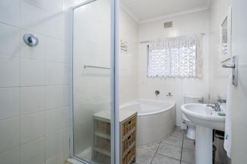a white bathroom with a tub and a sink at Breathtaking views from Sue Casa 11 in Margate