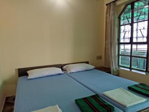 a bedroom with a bed with two pillows and a window at Scindhia Guest House in Varanasi