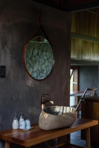 a bathroom with a stone sink and a mirror at The Ruong Resort in Vung Tau