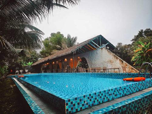 a swimming pool in front of a resort at The Ruong Resort in Vung Tau