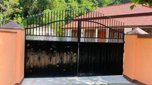 a black gate in front of a house at RED ROSE HOLIDAY HOUSE in Matara