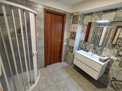 a bathroom with a sink and a shower and a mirror at La Penisola in Santa Maria La Carità