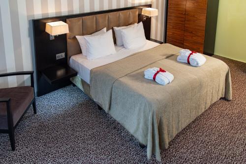 a hotel room with a bed with two pillows on it at Hotel Avance in Bratislava