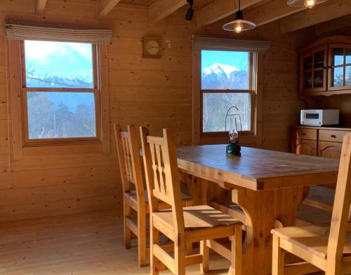 a dining room with a wooden table and chairs at Place yatsugatake Oigamori cottage - Vacation STAY 93259v in Hokuto