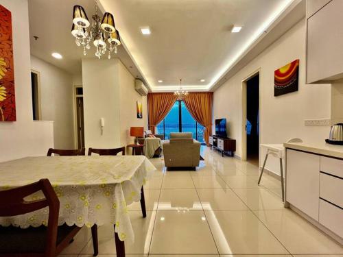 a dining room and living room with a table and a kitchen at Citrine Hub in Sunway Iskandar by Cowidea in Kampong Pendas