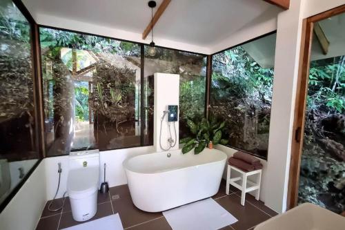 a bathroom with a white tub and some windows at Remote Home near Secret Lagoon with Motorcycle in Siquijor