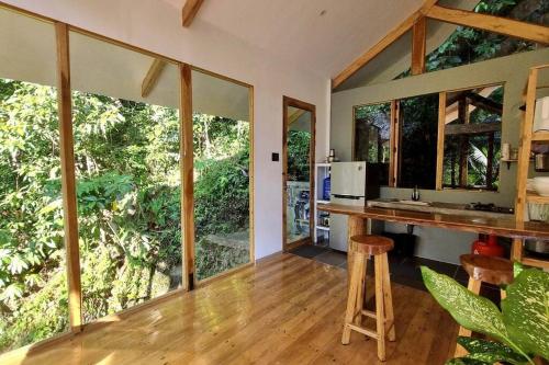 uma cozinha com um balcão e janelas grandes em Remote Home near Secret Lagoon with Motorcycle em Siquijor