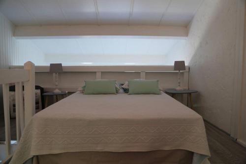 une chambre avec un lit avec deux oreillers verts dans l'établissement plein ciel A 83, à La Croix-Valmer