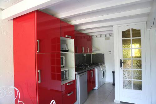 Il comprend une cuisine équipée de placards rouges et d'un réfrigérateur rouge. dans l'établissement plein ciel A 83, à La Croix-Valmer