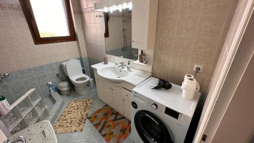 a bathroom with a washing machine in a sink at Beach apartment next to the temple of Hera in Samos
