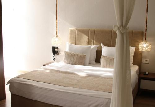 a bedroom with a large bed with white sheets and pillows at Hotel Driada in Gjakove