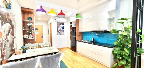 a kitchen with white cabinets and a blue wall at STAR APARTMENT- BEACH FRONT in Quy Nhon
