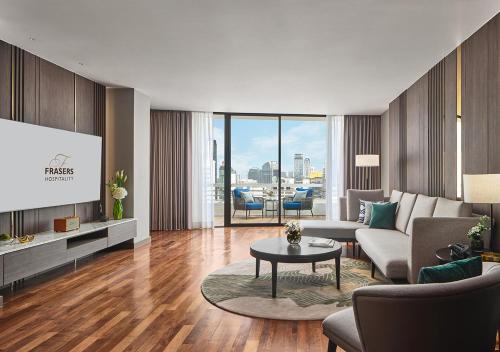 a living room with a couch and a tv at Fraser Suites Sukhumvit Bangkok in Bangkok