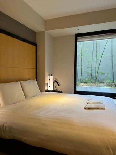 a bedroom with a large bed with a large window at KOKO HOTEL Premier Kanazawa Korinbo in Kanazawa