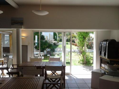 ユー島にあるHôtel L'Escale à l'ile d'Yeuのリビングルーム(テーブル、大きなガラスドア付)
