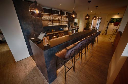 a bar with a row of chairs in a restaurant at Hotel-Restaurant Römerhof Superior in Herrenberg