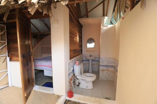 a bathroom with a toilet in a room at The Tasty Tuna Cabana in Arugam Bay