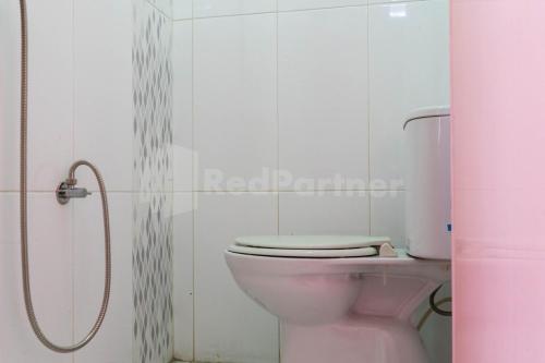 een roze toilet in een badkamer met een douche bij Asri Residence near Jalan Iskandar Muda Medan RedPartner in Medan
