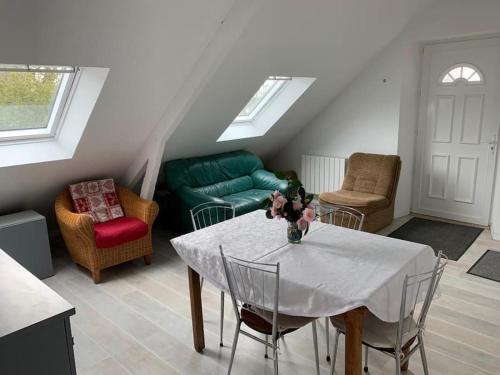 a living room with a table and chairs at Appartement dans maison de campagne au calme in La Trinité-sur-Mer