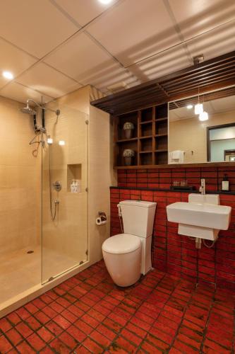 a bathroom with a toilet and a sink and a shower at The Grand Napat in Chiang Mai