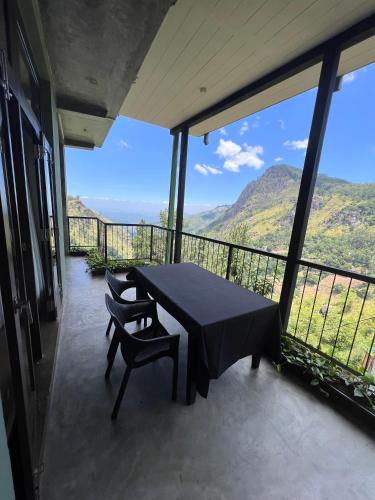 a table and chairs on a balcony with a view at Star Gaze Lodge in Ella