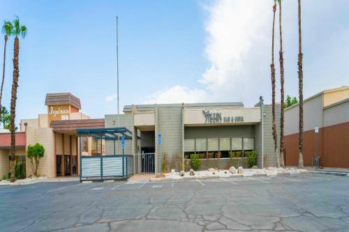 een parkeerplaats voor een gebouw met palmbomen bij Royal Plaza Inn in Indio