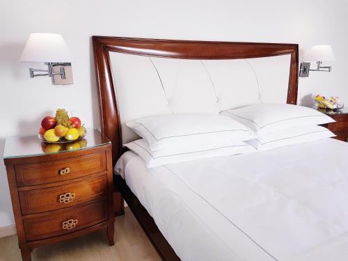 a bedroom with a bed and a bowl of fruit on a night stand at Villa Bellavista Alba, B&B in Alba