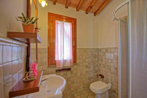 ein Bad mit einem Waschbecken, einem WC und einem Fenster in der Unterkunft Villa Roberto by PosarelliVillas in Fontanella