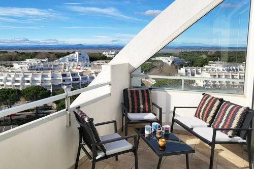 un balcon avec deux chaises et une table avec vue dans l'établissement Le Panoramique * Vue Mer Exceptionnelle * Clim * Véranda * Parking Privé * Front de mer, à La Grande Motte