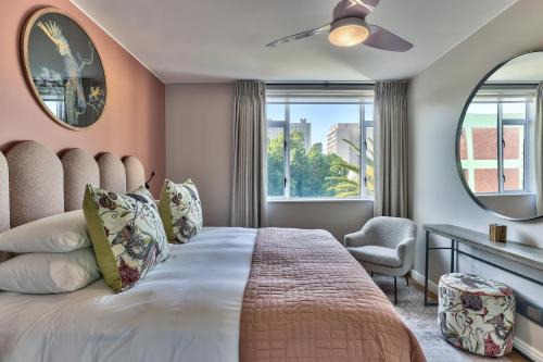 a bedroom with a large bed with a large window at 437 St Martini Gardens Apartments in Cape Town