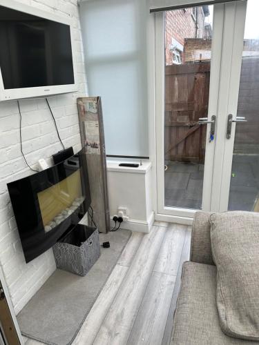 a living room with a couch and a tv on a wall at A place of Rest in Middlesbrough