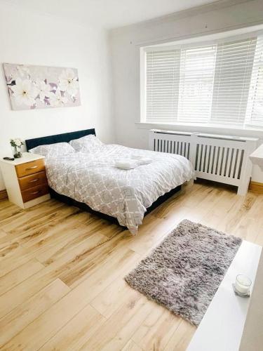 a bedroom with a bed and a wooden floor at A place of Rest in Middlesbrough