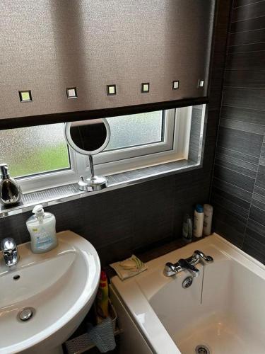uma casa de banho com um lavatório, um espelho e uma banheira em A place of Rest em Middlesbrough