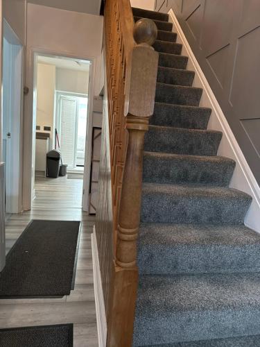 a staircase in a home with blue carpeting and wooden stairs at A place of Rest in Middlesbrough