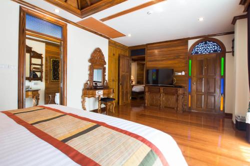 a bedroom with a bed and a desk in a room at Pingviman Hotel in Chiang Mai