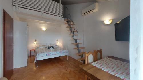 een kamer met een kinderbedje in een kamer met een trap bij Apartments Lucija-Klara in Brodarica