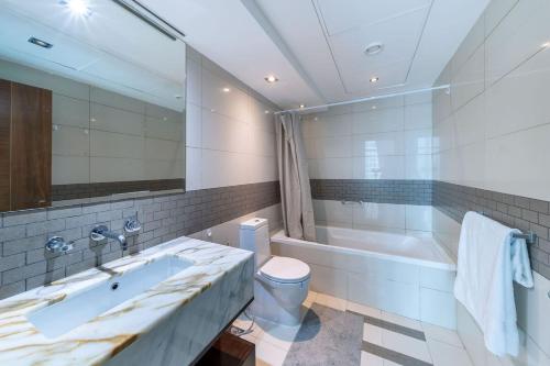 e bagno con vasca, servizi igienici e lavandino. di Heart of the Marina - 1 BR apartment a Dubai
