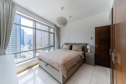 sypialnia z łóżkiem i dużym oknem w obiekcie Heart of the Marina - 1 BR apartment w Dubaju