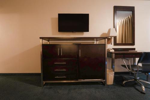 a entertainment center with a television on top of it at Royal Plaza Inn in Indio