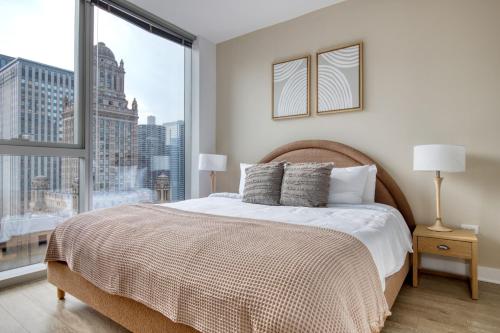 een slaapkamer met een bed en een groot raam bij Loop 2br w gym playroom pool close to L CHI-960 in Chicago