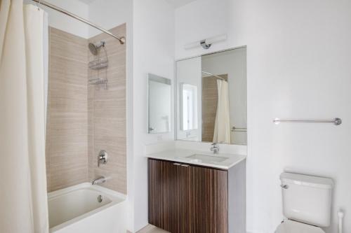 een badkamer met een wastafel, een bad en een toilet bij Loop 2br w gym playroom pool close to L CHI-960 in Chicago