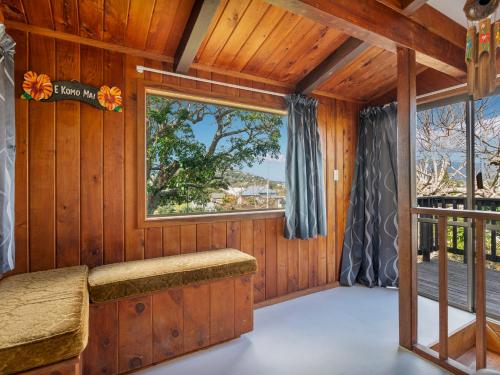 a room with a window in a wooden house at Paku View Retreat - Tairua Holiday Home in Tairua