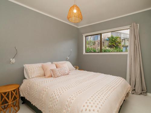 a bedroom with a bed and a window at Paku View Retreat - Tairua Holiday Home in Tairua